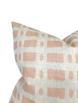 Close-up of a pillow cover with a soft pink and white geometric grid pattern featuring rectangles and ovals on textured fabric.