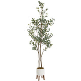 Tall faux eucalyptus tree with slender brown stems and rounded green leaves, standing in a white cylindrical pot with four wooden legs against a white background.