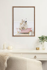 Framed canvas showing a mother polar bear and baby sitting inside a pink bathtub with white wooden panel background and a small vase of pink roses.