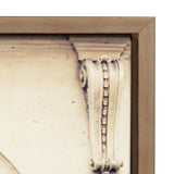 Close-up of a beige carved architectural detail with a scroll and bead pattern, bordered by a medium wood frame corner with mitered edges.