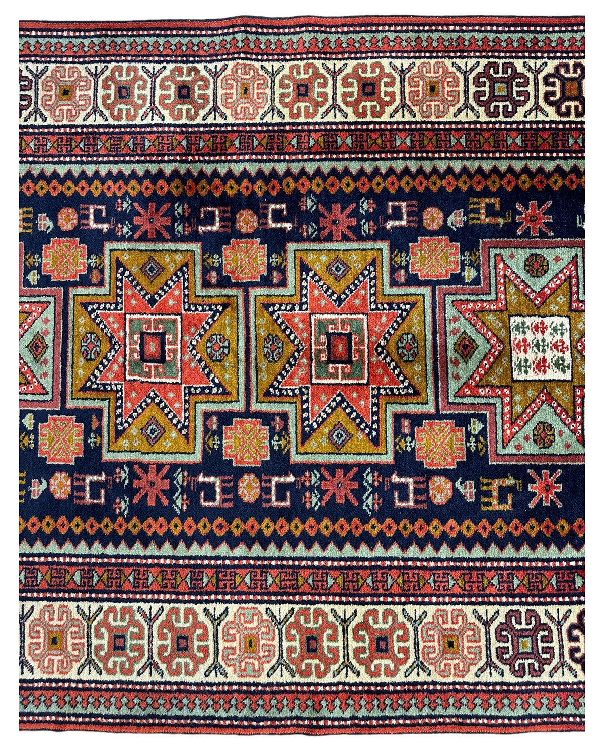 Vintage Armenian Karabakh rug with large geometric star motifs in red, yellow, green, and white on a navy blue field, bordered by repeating intricate floral and abstract patterns.