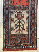 Vintage Kurdish Qochan runner rug with a central geometric tree motif and intricate diamond and floral patterns in red, brown, and cream hues within multiple borders.