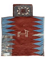 Rectangular vintage Baluch salt bag rug with a central animal motif on a rust-red field, bordered by blue triangular patterns and a small attached pouch with geometric designs.