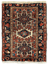 Small vintage Persian runner in deep reds and navy with a central geometric medallion and intricate border patterns, finished with light fringe on both ends.