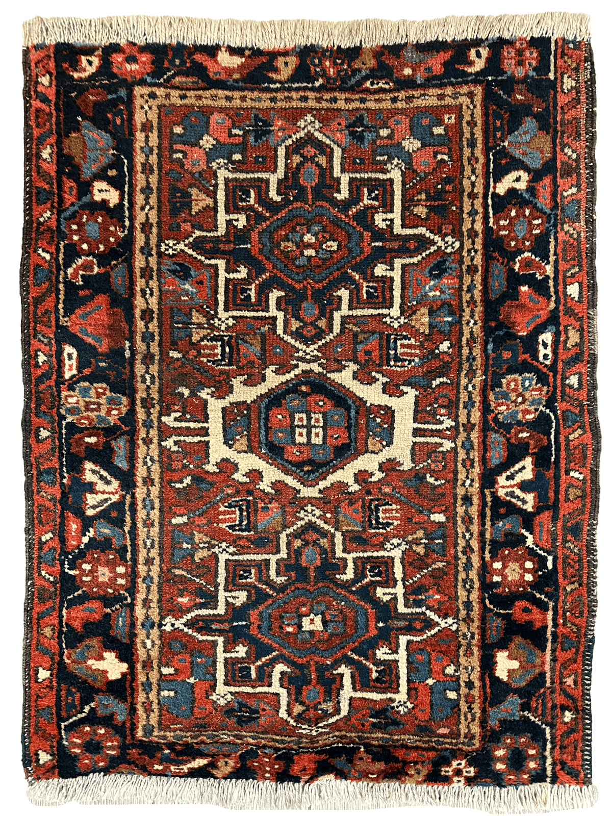 Small vintage Persian runner in deep reds and navy with a central geometric medallion and intricate border patterns, finished with light fringe on both ends.