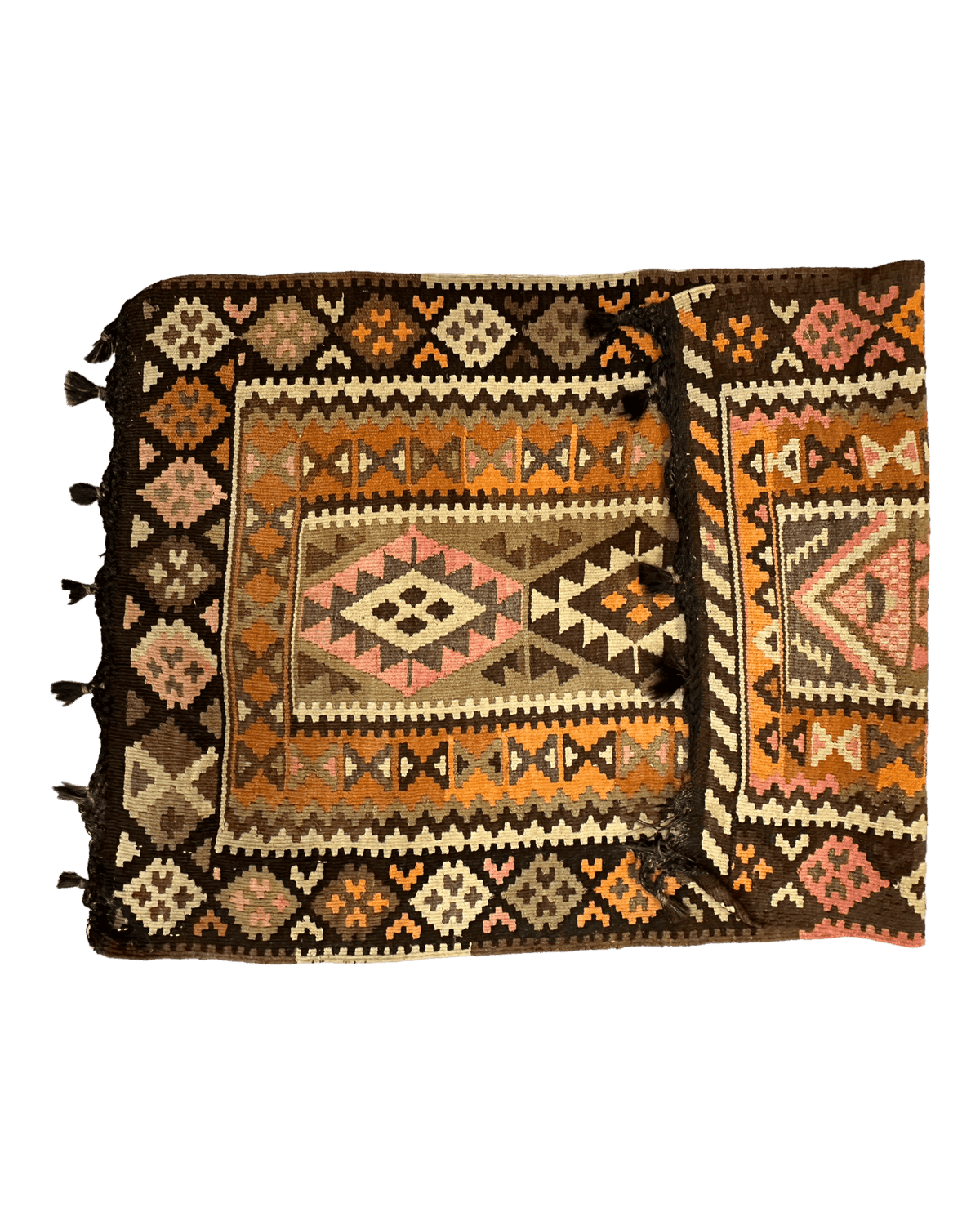 Folded vintage Persian Qashqai Kilim rug with geometric diamond patterns in earthy tones of brown, orange, pink, and cream, featuring tassels on one side.