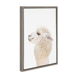 Side profile of a white alpaca with fluffy fur on a plain white background, presented in a narrow gray wooden frame.