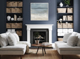 Contemporary living room with two beige sofas facing each other, a round wooden coffee table, blue-gray walls, built-in shelves with wicker baskets, and an abstract landscape painting above a white fireplace.