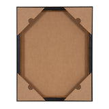 Back view of a framed canvas with brown paper corners securing the canvas inside a black frame, showing canvas texture and wooden stretcher bars