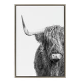 Black and white close-up of a Highland cow showing one long curved horn and shaggy fur covering its eyes, framed in a simple rectangular frame.