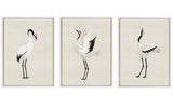 Three framed canvas art pieces depicting minimalist Japanese cranes with red crowns, arranged side by side on a neutral wall.