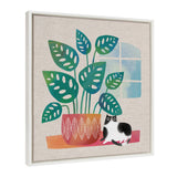 Framed canvas artwork showing a stylized potted plant with blue-green leaves next to a black-and-white cat, with a window casting soft light behind.