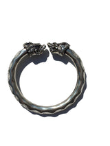 Antique Norse Viking bracelet in silver with two detailed lion heads facing each other and a waved pattern along the circular band.
