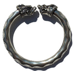 Antique Norse Viking Bracelet showing two lion heads twisting around with waved pattern on white background
