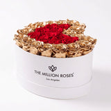 White heart-shaped box filled with red and 24K gold roses