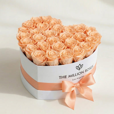 Heart-shaped white box filled with peach roses