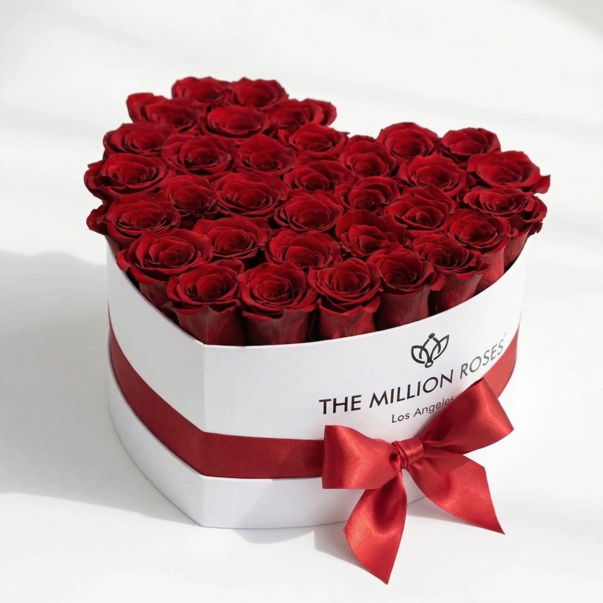 Heart-shaped white box filled with 28-30 red roses by The Million Roses