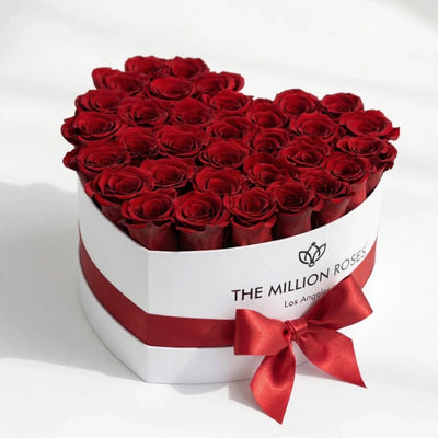 Heart-shaped white box filled with 28-30 red roses by The Million Roses