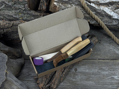 Beginner wood carving kit with sloyd knife, hook knife, wooden blank, sandpaper, sharpening board, pencil, and finger wrap