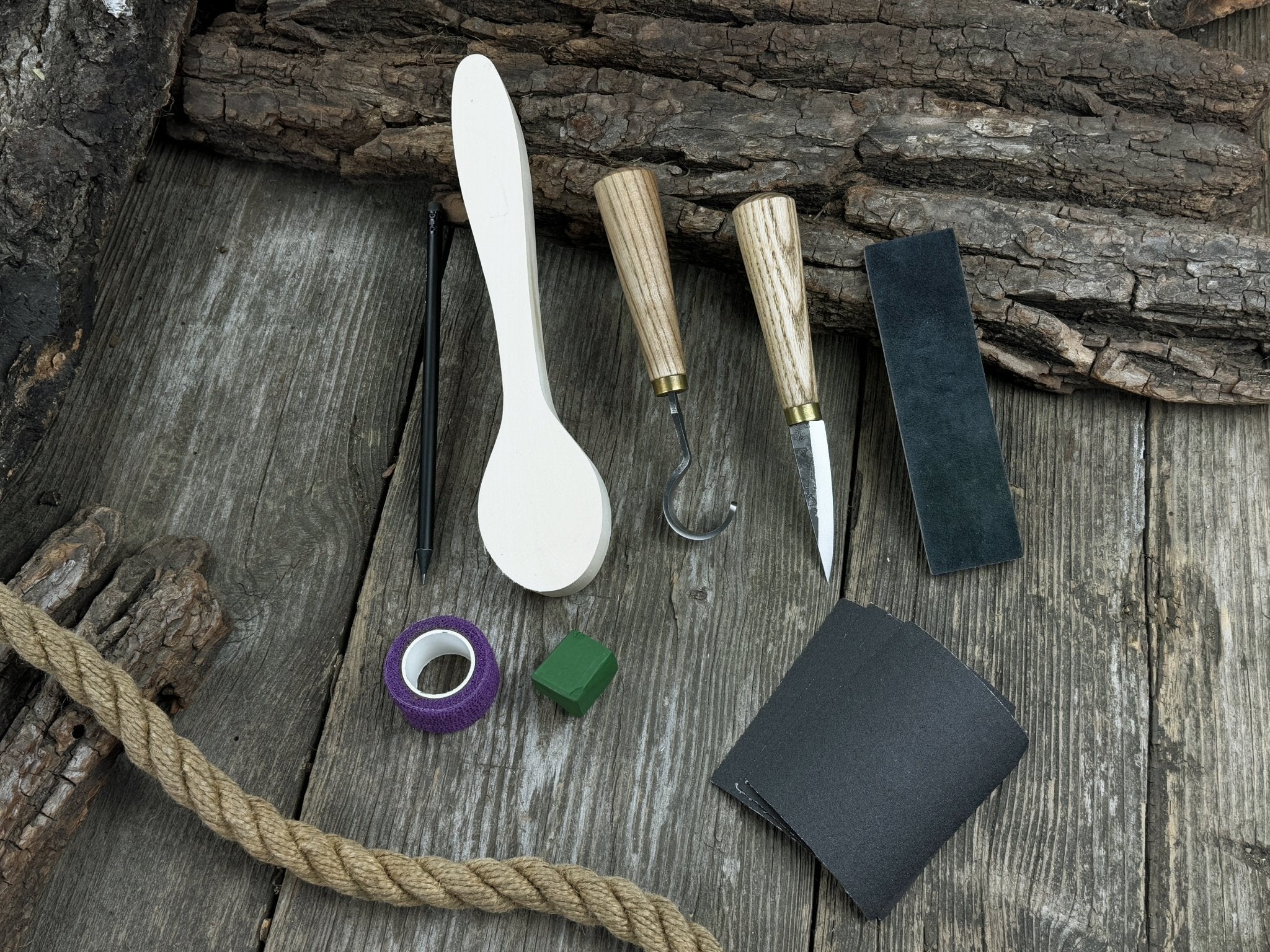 Wood Whittling Starter Kit with sloyd knife, hook knife, wooden blank, sandpaper, sharpening board, pencil, and finger wrap