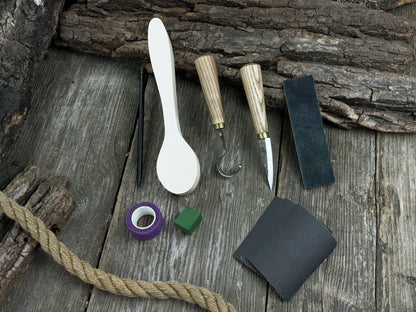 Wood Whittling Starter Kit with sloyd knife, hook knife, wooden blank, sandpaper, sharpening board, pencil, and finger wrap