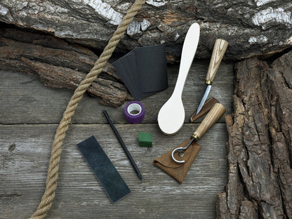 Wood Whittling Starter Kit with sloyd knife, hook knife, wooden blank, sandpaper, sharpening board, pencil, and finger wrap