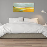 Abstract landscape painting above a bed, featuring horizontal bands of green, yellow, and white hues in a simple light wood frame against a gray wall.