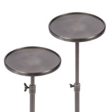 Two round polished metal tables with slightly raised edges and adjustable height mechanisms, shown side by side with one taller than the other.