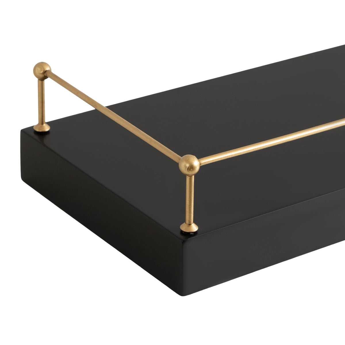 Close-up of a black rectangular floating shelf with a thin, gold-colored metal railing along one edge featuring spherical connectors at the corners.
