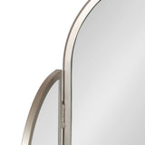 Close-up of a tri-fold metal mirror with an arch-shaped frame in a brushed silver finish showing two hinged panels.