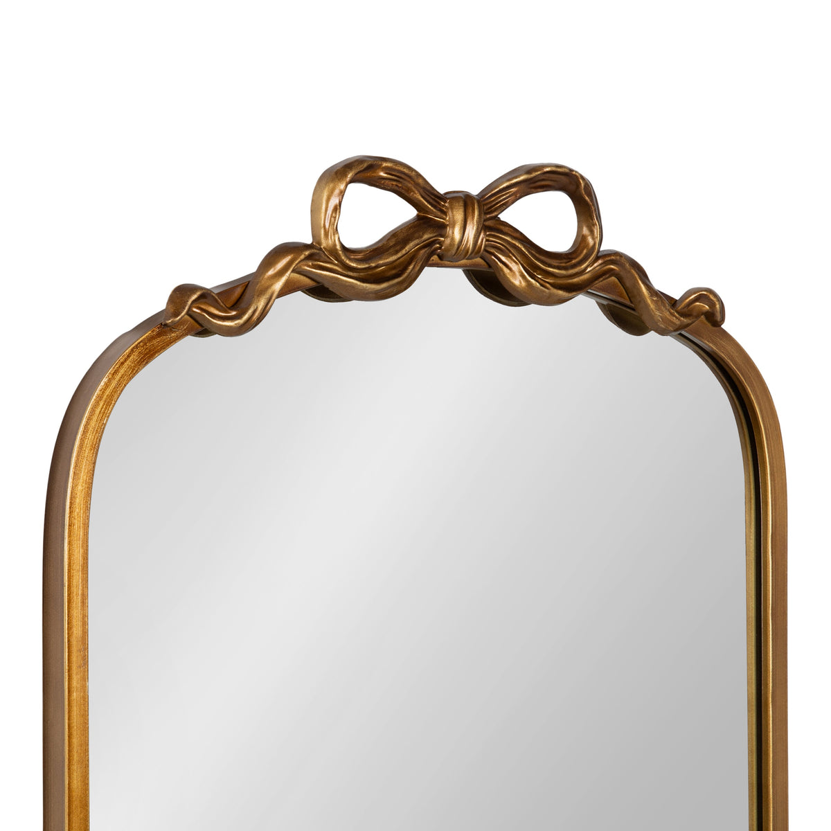 Arched mirror with a gold frame featuring a sculpted ribbon bow detail at the top center and softly curved edges.