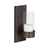 Dark bronze metal wall sconce with vertical ridges on the rectangular backplate and clear cylindrical glass holder containing a white candle.