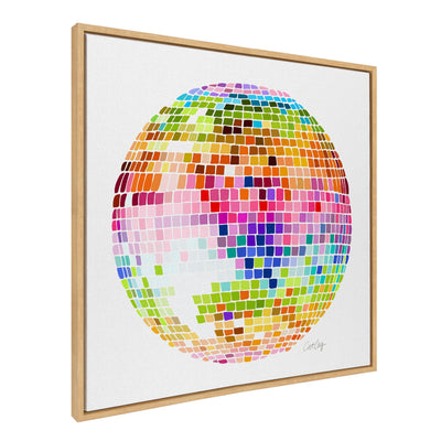 Sylvie Rainbow Disco Ball Framed Canvas Art by Cat Coquillette, showing bright multicolored disco ball on black background in a light frame