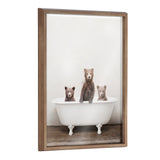 Three brown bear cubs standing and sitting inside a white vintage clawfoot bathtub against a plain background, framed in natural wood.