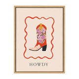 Framed canvas art depicting a red cowboy boot adorned with pink flowers and yellow detailing, enclosed by a wavy red border and labeled 'HOWDY' below.