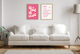 Living room with a beige upholstered sofa beneath two framed canvases; left canvas bright pink with 'Be Nice or Leave' text, right canvas white with handwritten 'Rules' in red and purple.