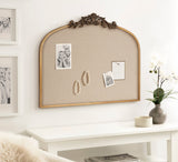 Arched fabric pinboard with ornate dark brown carving along top edge, framed in light wood, displayed above white console table with vase and decor.