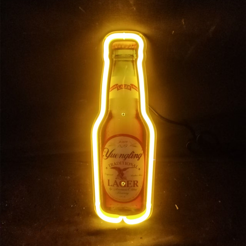 Yellow neon light outlining a Yuengling Lager beer bottle against a dark background, highlighting the bottle's shape and label details.