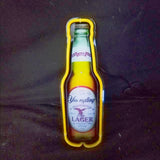 Illuminated neon sign shaped like a Yuengling Traditional Lager beer bottle with yellow neon outlining the bottle shape against a dark background.