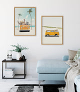 Two framed canvases showing yellow camper vans; left has animals and palm trees by the ocean, right shows van on sandy dune with green bushes