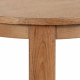 Close-up of a round wooden side table edge and leg made from medium-tone wood with visible grain and subtle knots against a white background