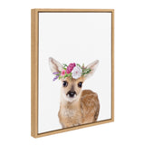 Young fawn with white spots wearing a pink and white flower crown, framed in light wood against a white background.