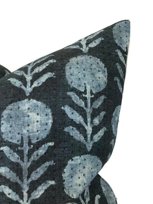 Dark indigo blue pillow cover featuring a repeating zinnia flower pattern in lighter blue tones with leaf and stem details.