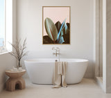Minimalist bathroom with white freestanding tub and beige towel, featuring a framed Sylvie Ficus Elastica canvas artwork with pink background above the tub.