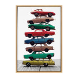 Vertical stack of eight vintage cars in various colors including red, green, blue, and yellow on a wooden surface with a white background.