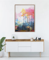 Framed abstract forest canvas with tall, thin black trunks and vibrant pink, yellow, and blue foliage, displayed above a modern wooden sideboard with decor.