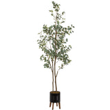 Tall faux eucalyptus tree with slender brown stems and round green leaves, planted in a black planter with three wooden legs against a white background.