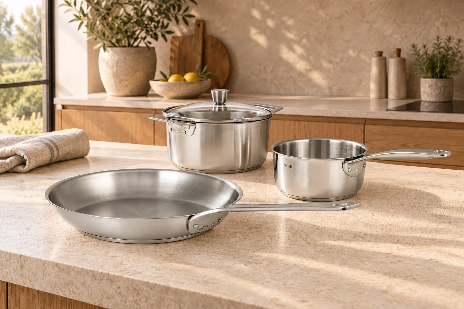 CRISTEL stainless steel frying pan styled on a warm limestone kitchen island